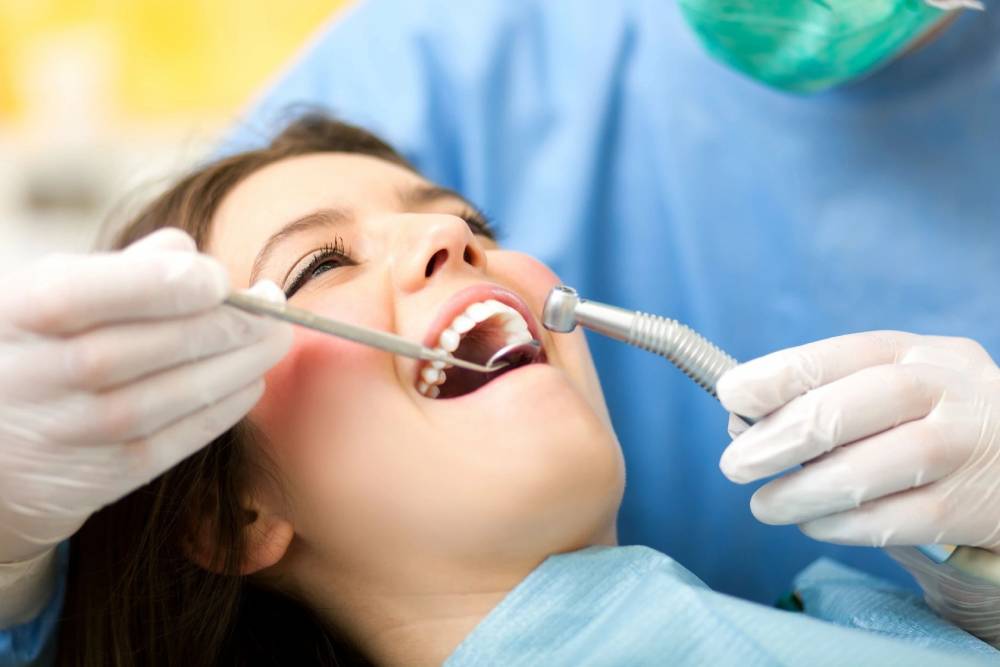 Dentist doing a dental treatment on a female patient